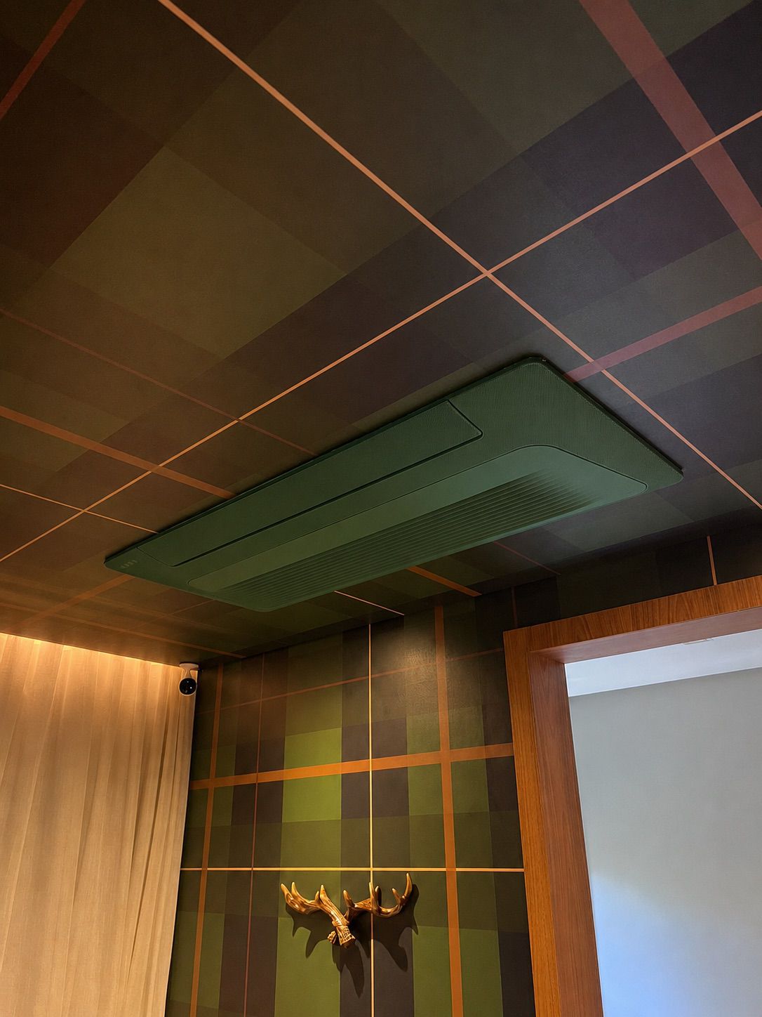 Cassete de teto pintado em verde integrado a forro decorativo