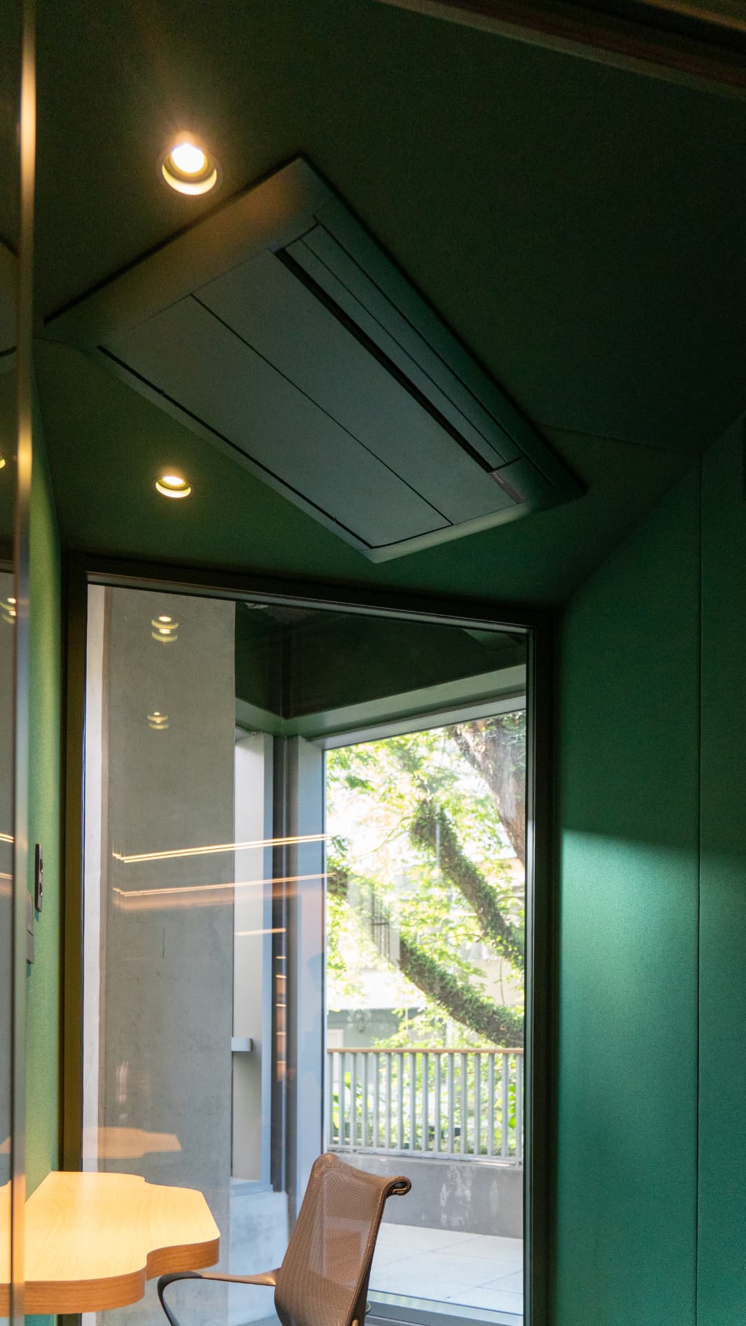 Cassete de teto pintado em verde-escuro em sala de reunião com teto na mesma cor